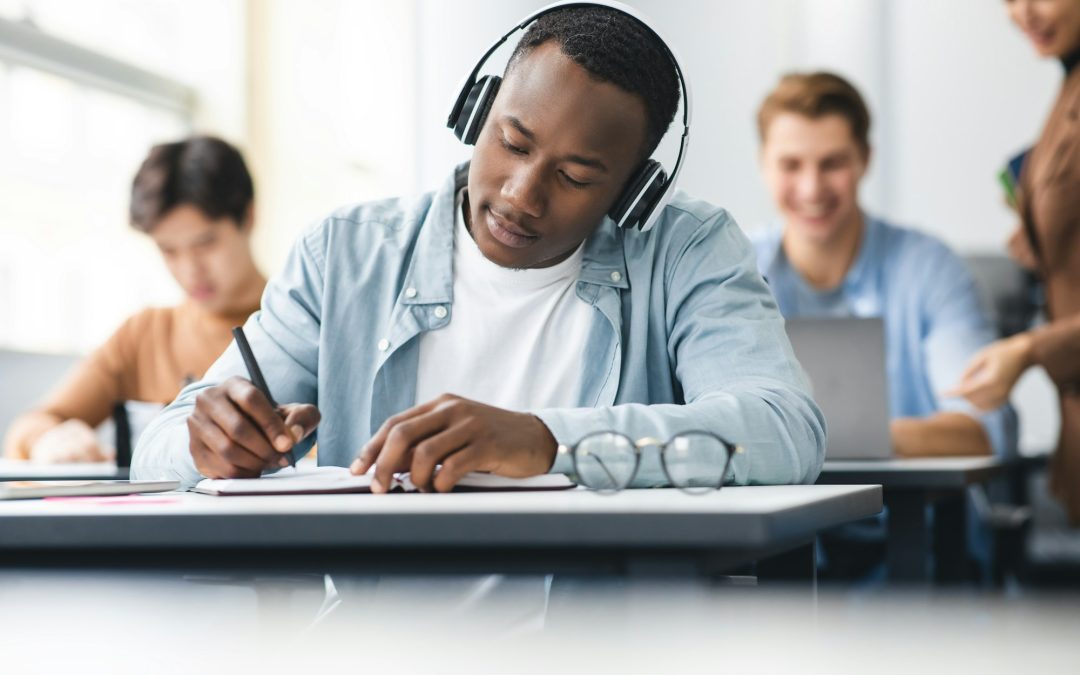 Black man sitting at desk in classroom writing exam